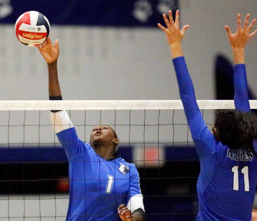 Plano West outside hitter Iman Ndiaye (1) makes a hit as Hebron right side K.C. Ortega (11)...