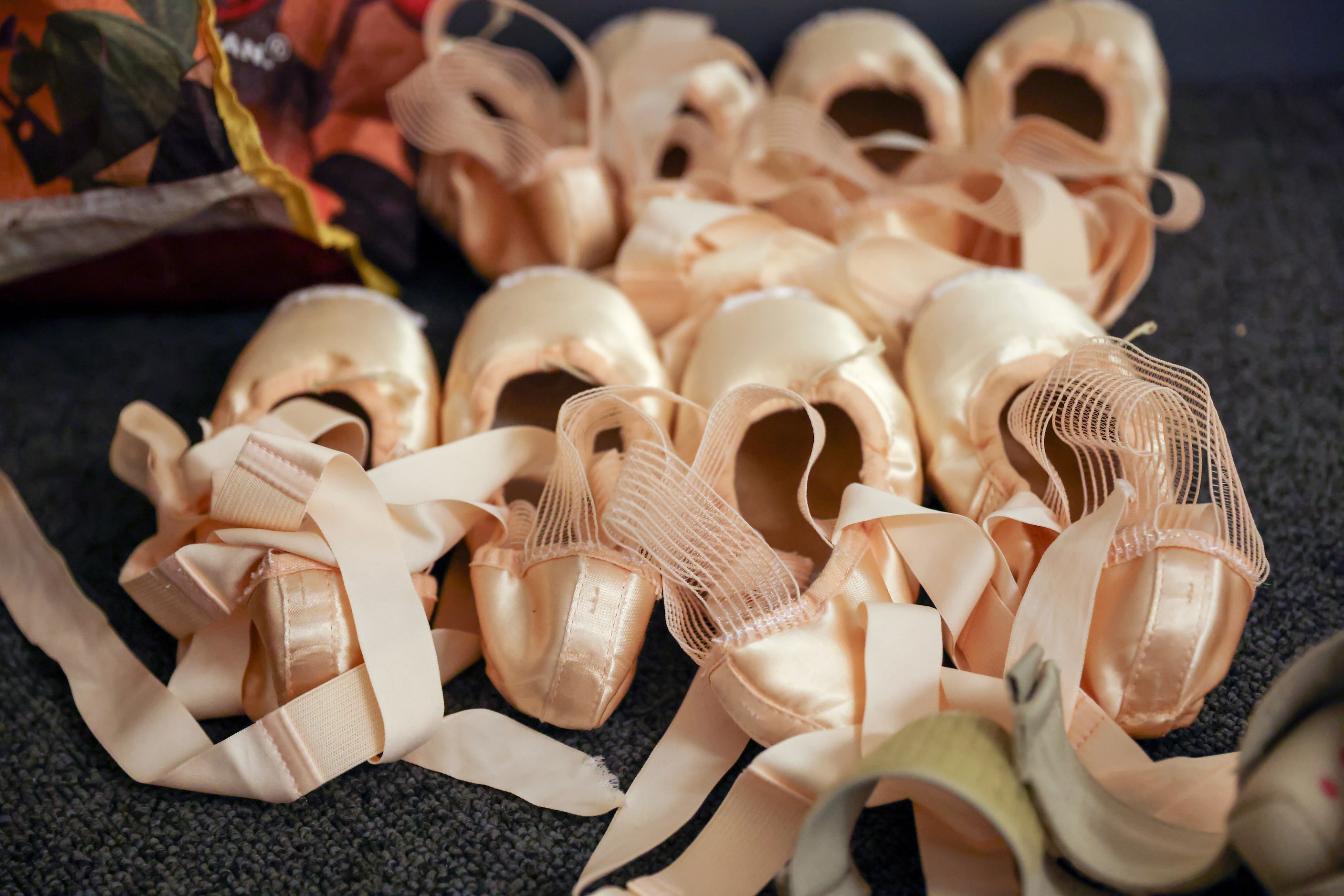 Sets of pointe shoes sit along the wall of Alexandra F. Light’s dressing room for her role...