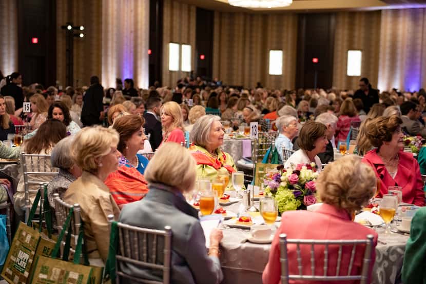 Women sitting at large tables in a ballroom.