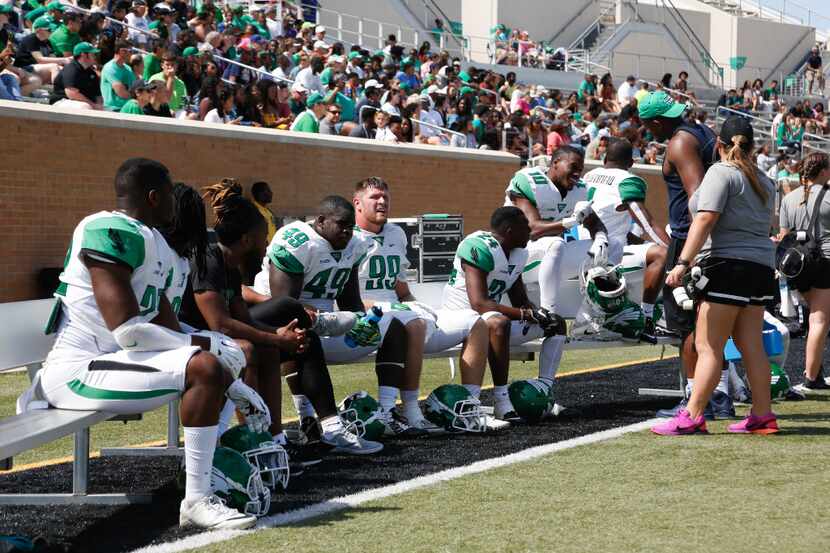 North Texas football players sit on the bench for some rest at Apogee Stadium, Saturday,...