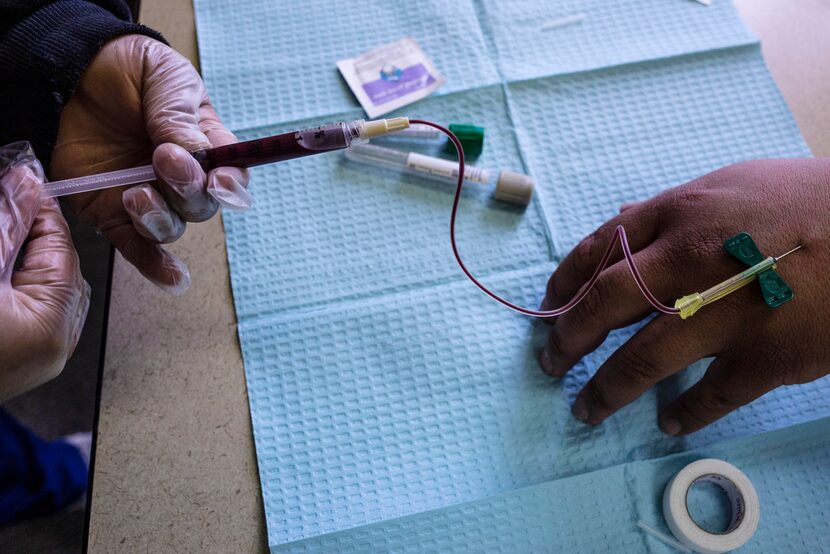 Student Jocelyn Marquez draws blood from Asael Codiz at West Dallas Community Church in Dallas.