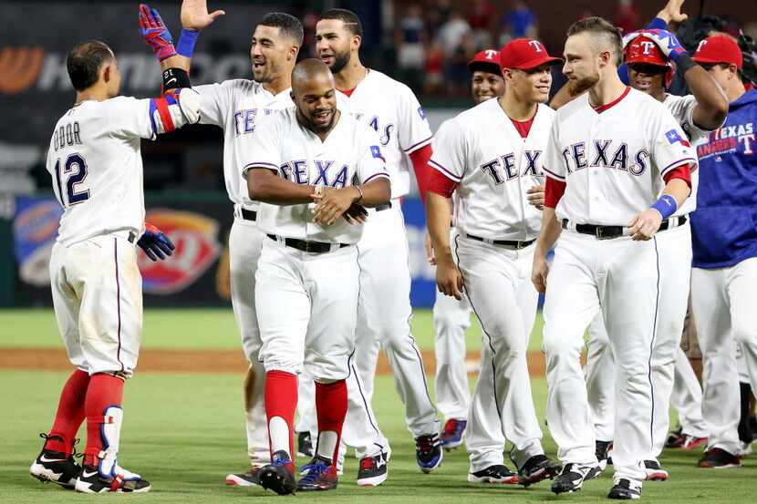 Texas Rangers second baseman Rougned Odor (12) celebrates with teammates after he was hit by...