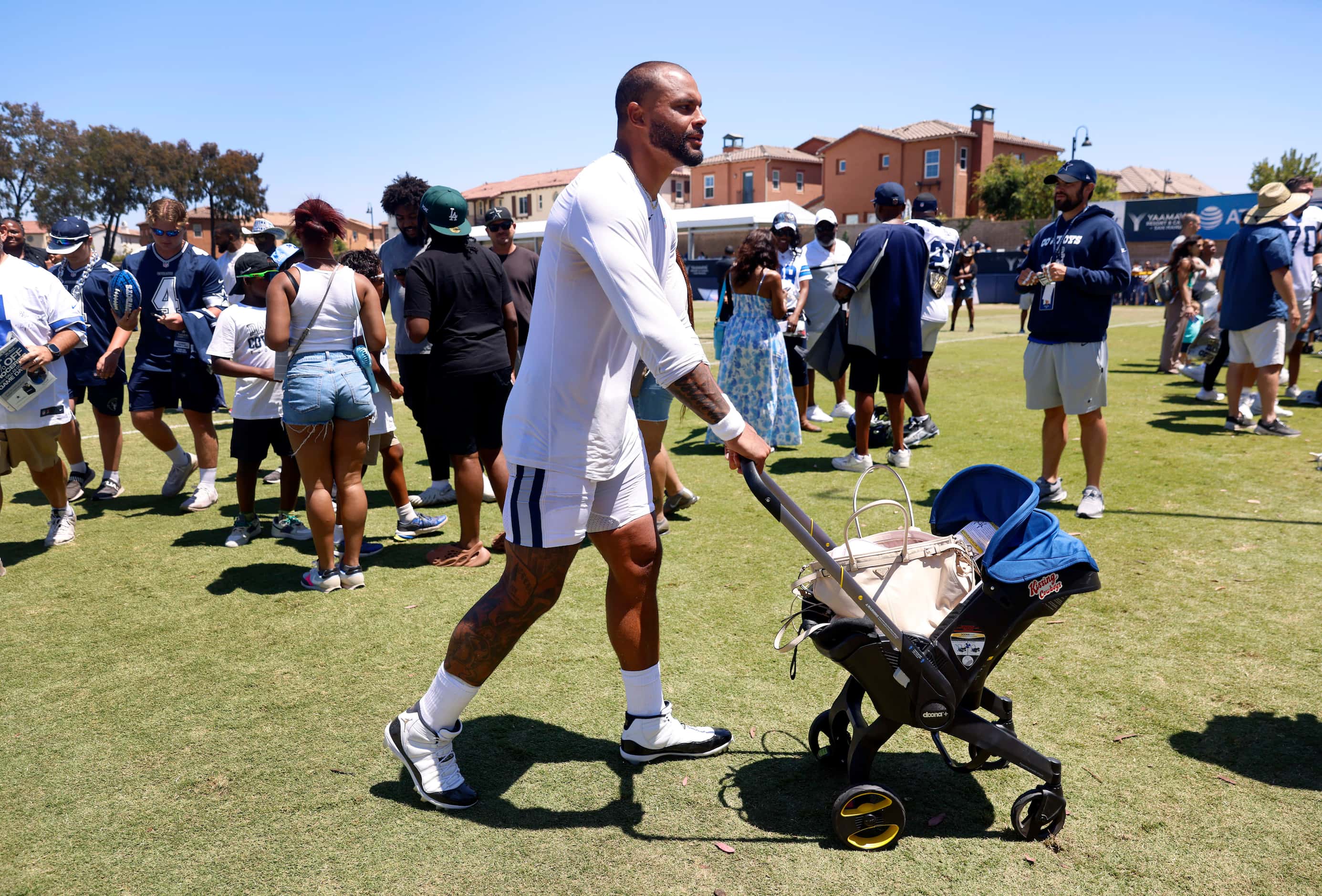 Dallas Cowboys quarterback Dak Prescott pushes the baby stroller as his girlfriend Sarah...