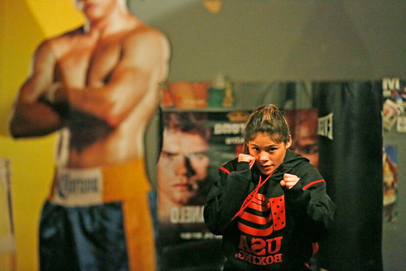 Hillary Perez  looks at herself in a mirror while running a drill in training at the...