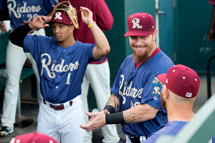 Texas Rangers outfielder Josh Hamilton relaxes with teammates in the dugout before playing a...