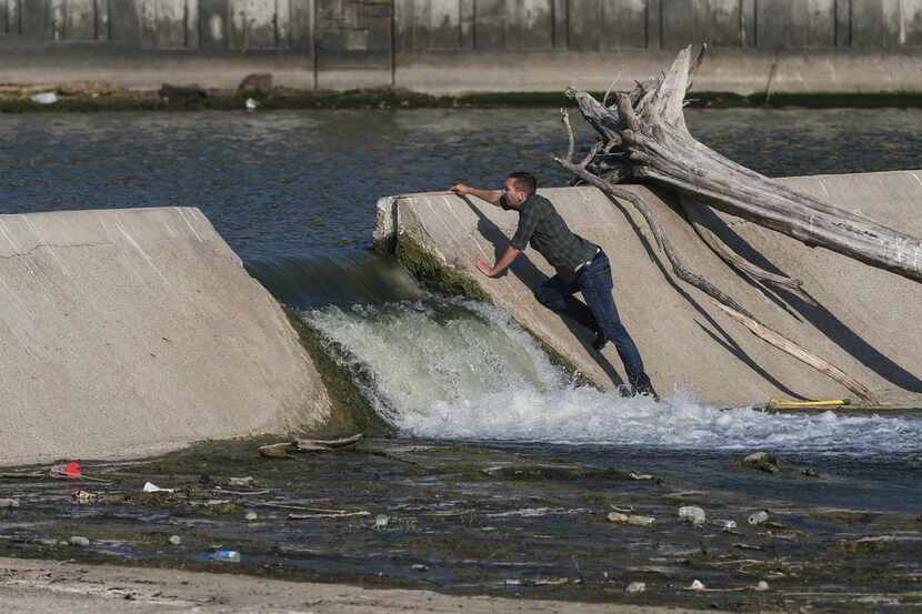 Officials survey the spillway at White Rock Lake on Thursday, July 25, 2019 in Dallas.