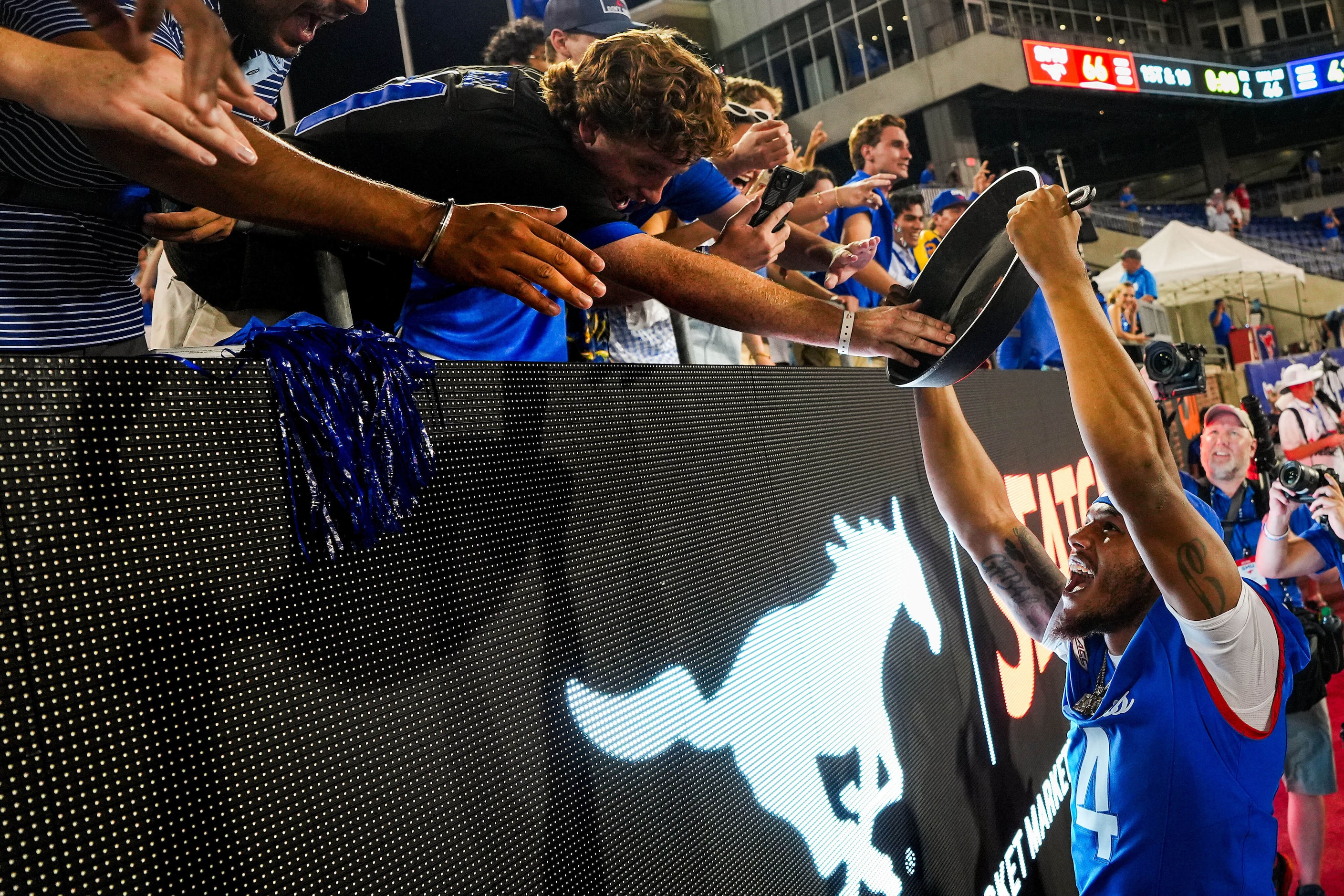 SMU running back Jaylan Knighton holds the Iron Skillet trophy up to the crowd as he...