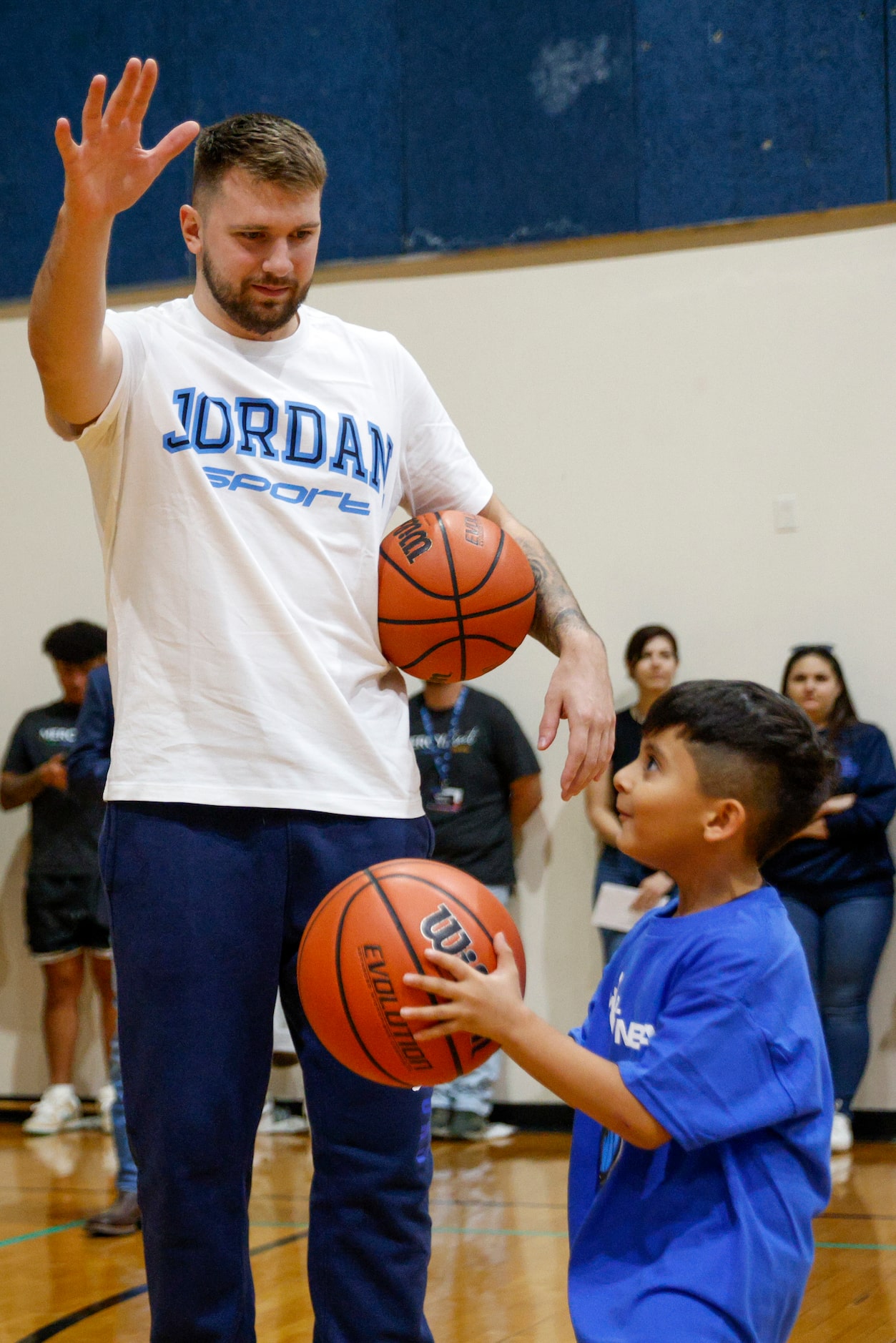 Dallas Mavericks guard Luka Doncic playfully defends against a child’s shot during a...