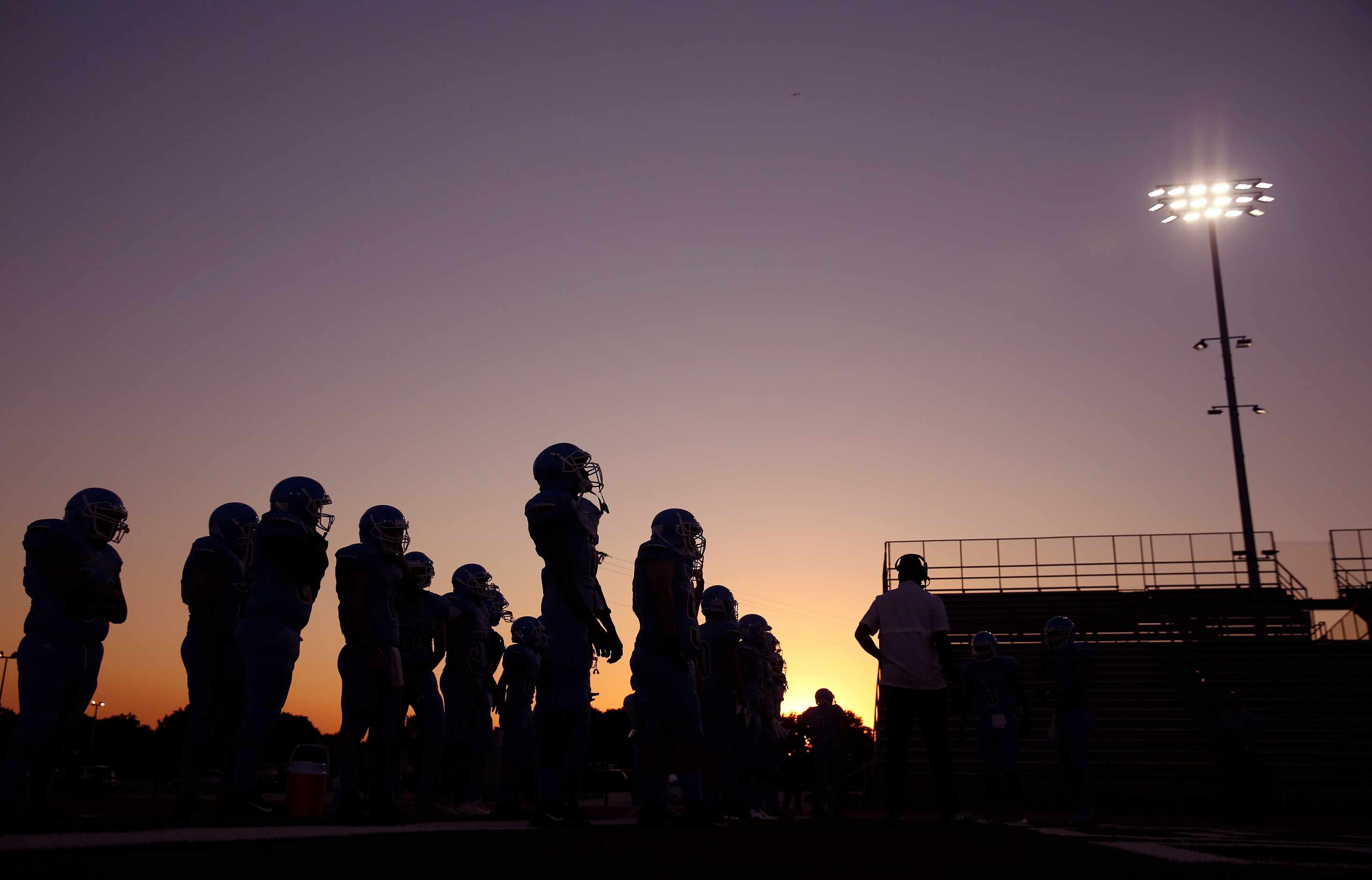 As the sun sets behind Loos Stadium, the Thomas Jefferson football team waits to take the...