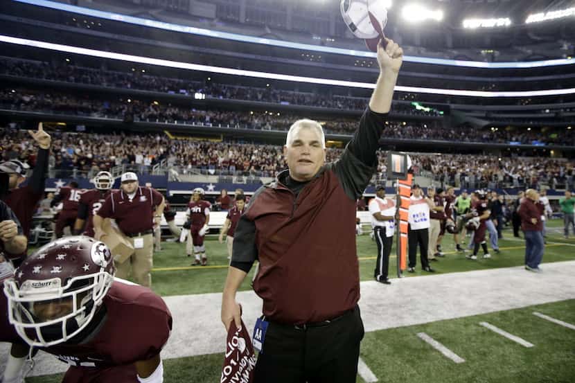 Ennis coach Jack Alvarez celebrates with his team as he walks onto the field in the final...