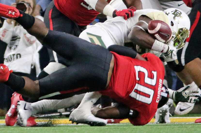 Baylor running back Terence Williams (22) fumbles near the goal line as Texas Tech...