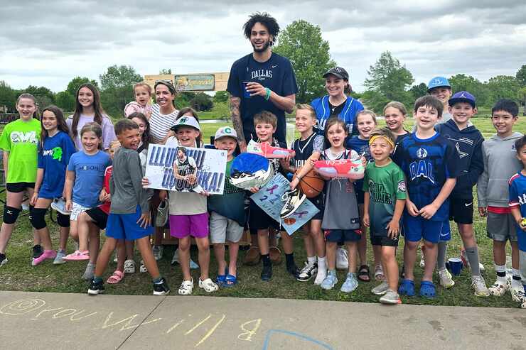 Dallas Mavericks rookie star Dereck Lively II (center) poses with Grapevine-Colleyville ISD...