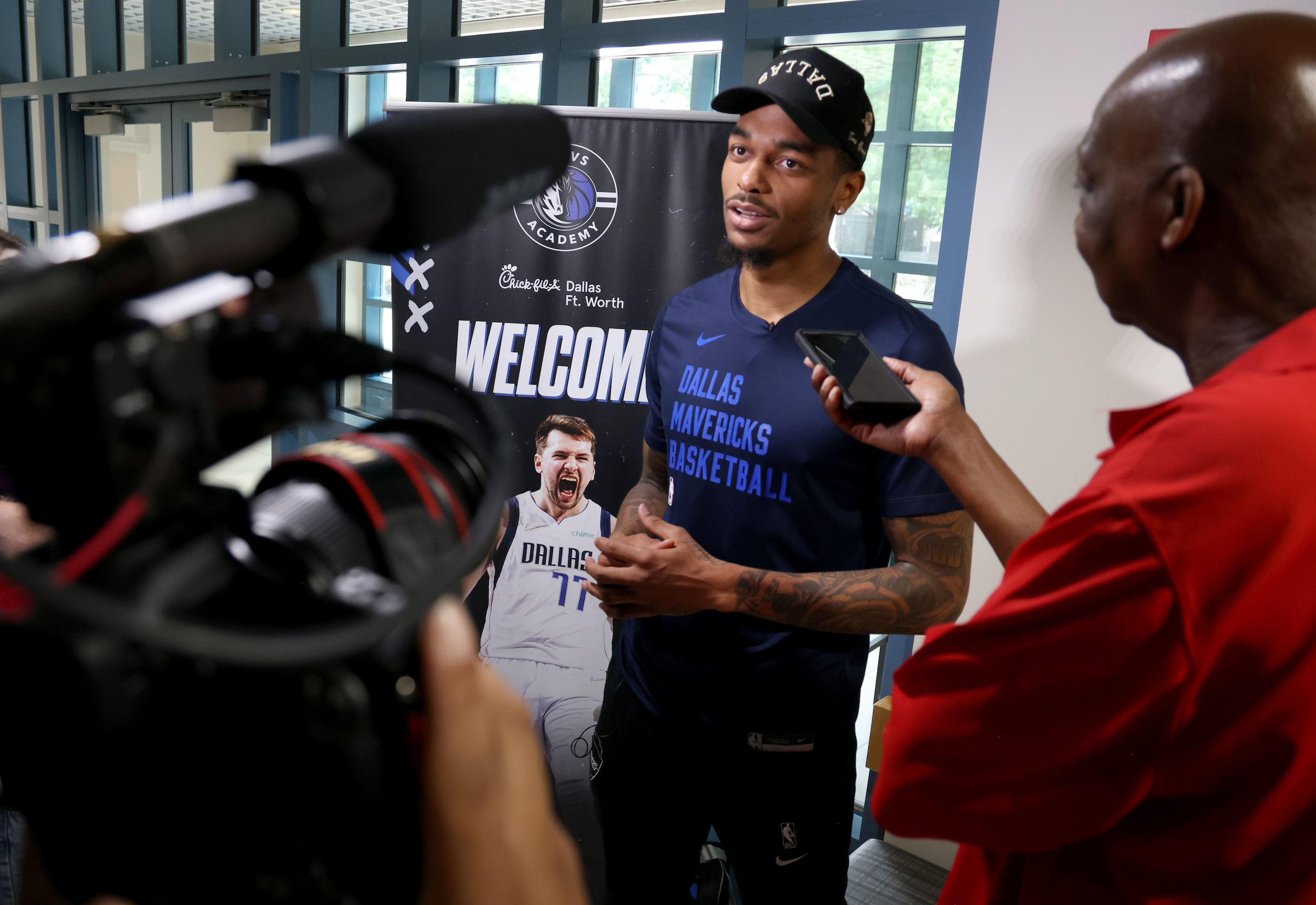 Dallas Mavericks forward and center PJ Washington answers a question from a media member...