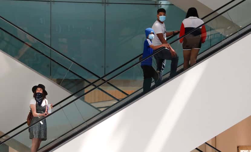 Amid concerns of the spread of COVID-19, shoppers wear masks inside the Galleria Dallas mall...