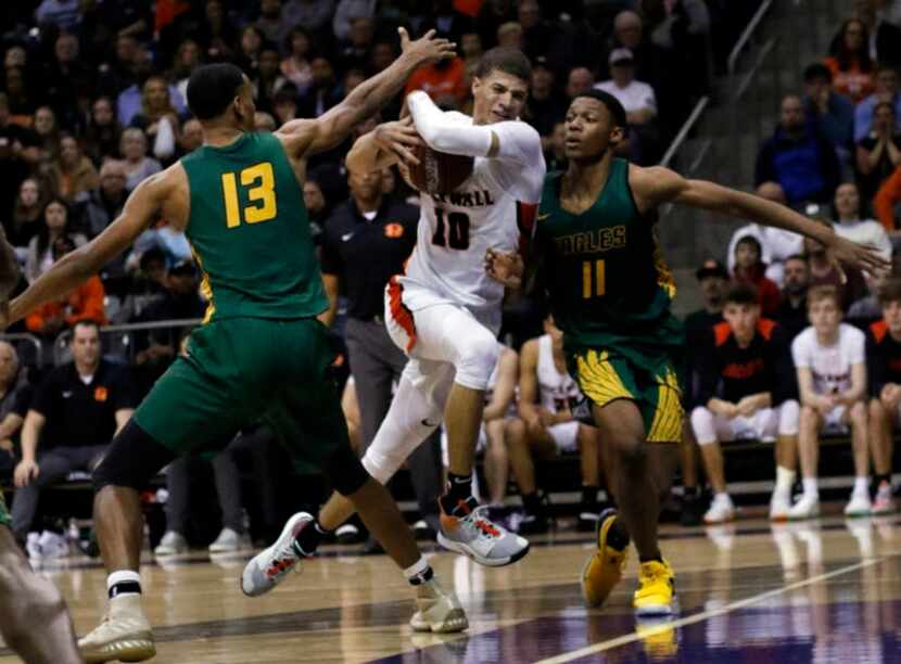 Rockwall senior guard Samuell Williamson (10) drives hard to the basket between the defense...