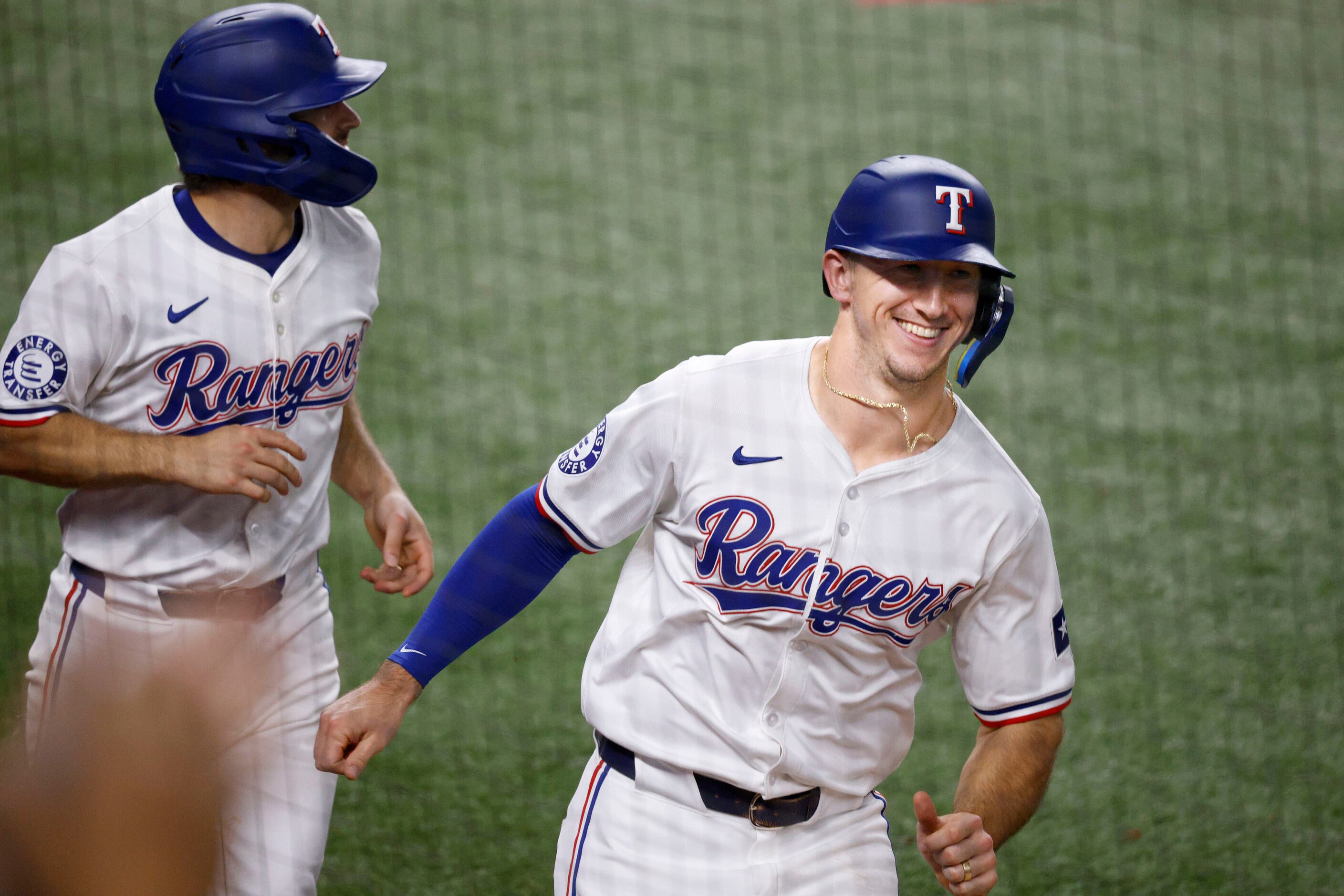 Texas Rangers’ Josh Smith (8), left, and Texas Rangers’ Wyatt Langford (36) run to the bench...