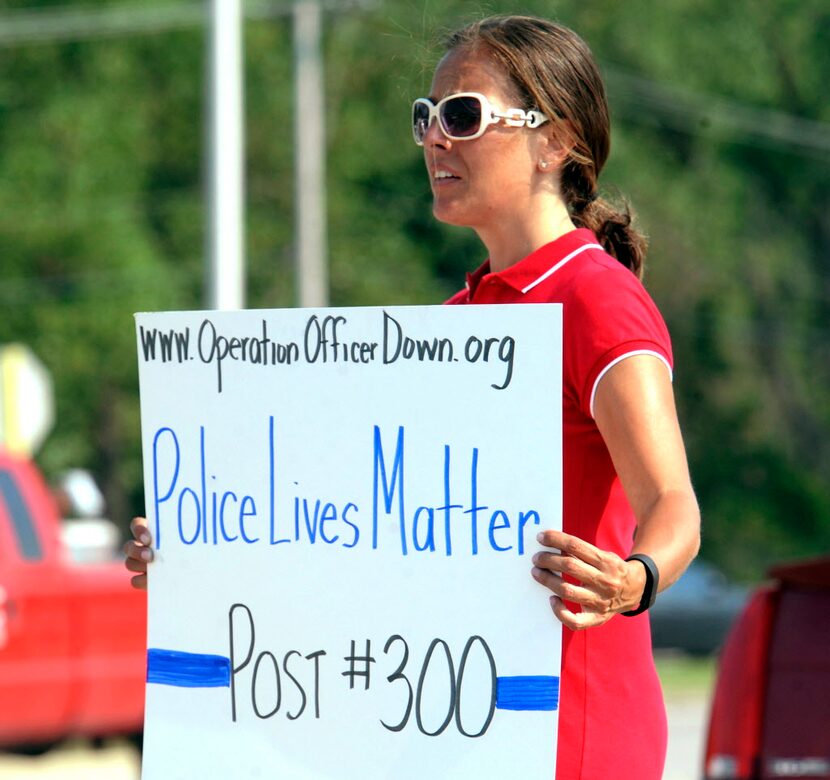 
A volunteer demonstrates her support for police after the shooting of an officer in Fox...