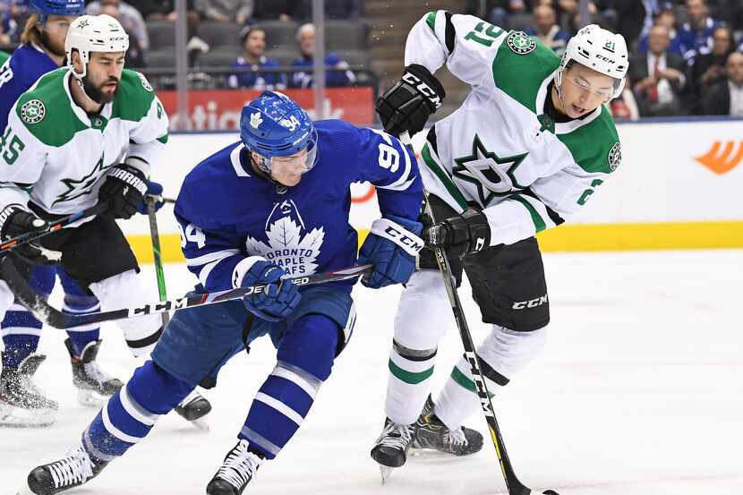 Dallas Stars Left Wing Jason Robertson (21, right) is defended by Toronto Maple Leafs...