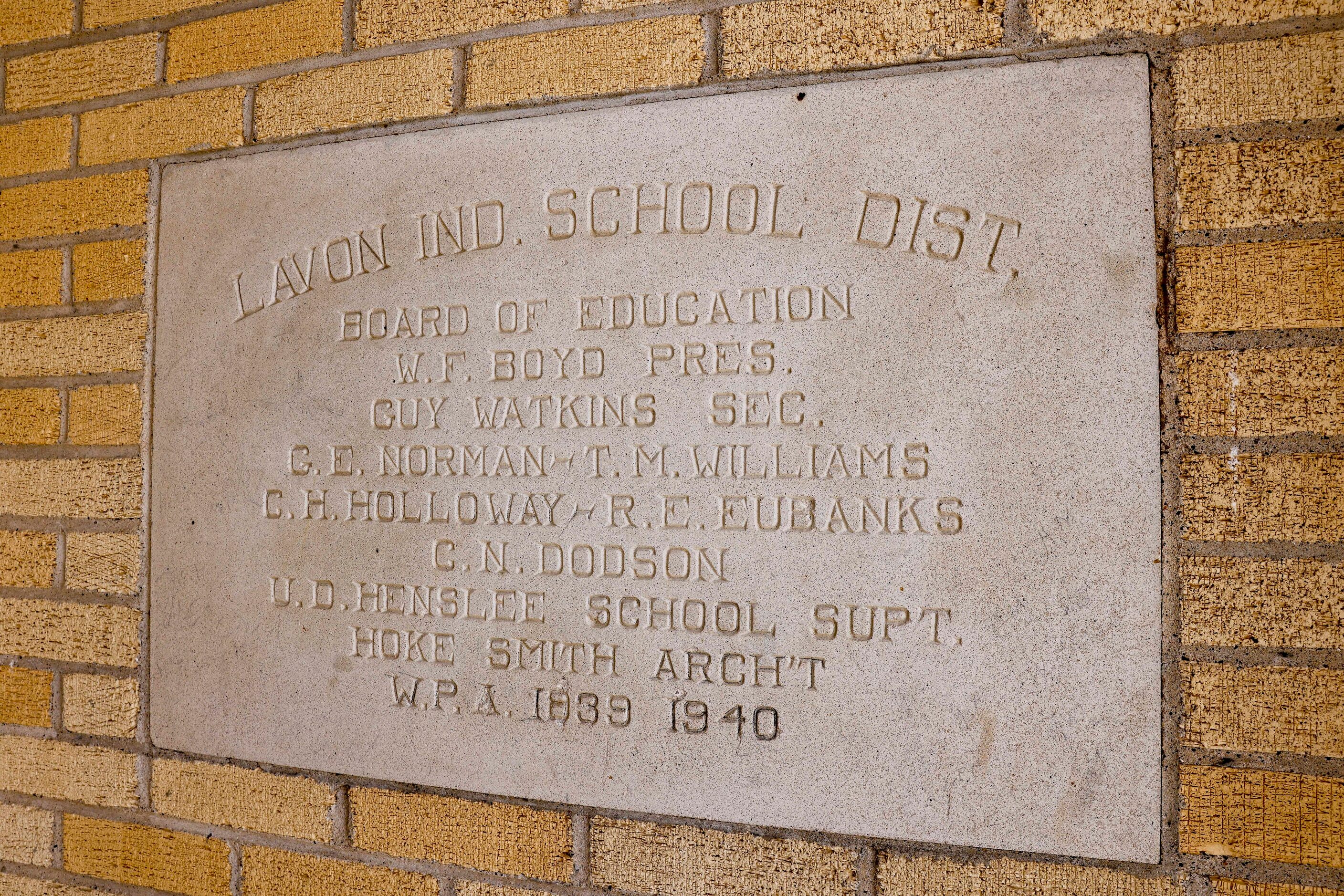 A plaque memorializes the construction of the school building that now serves as the Lavon...