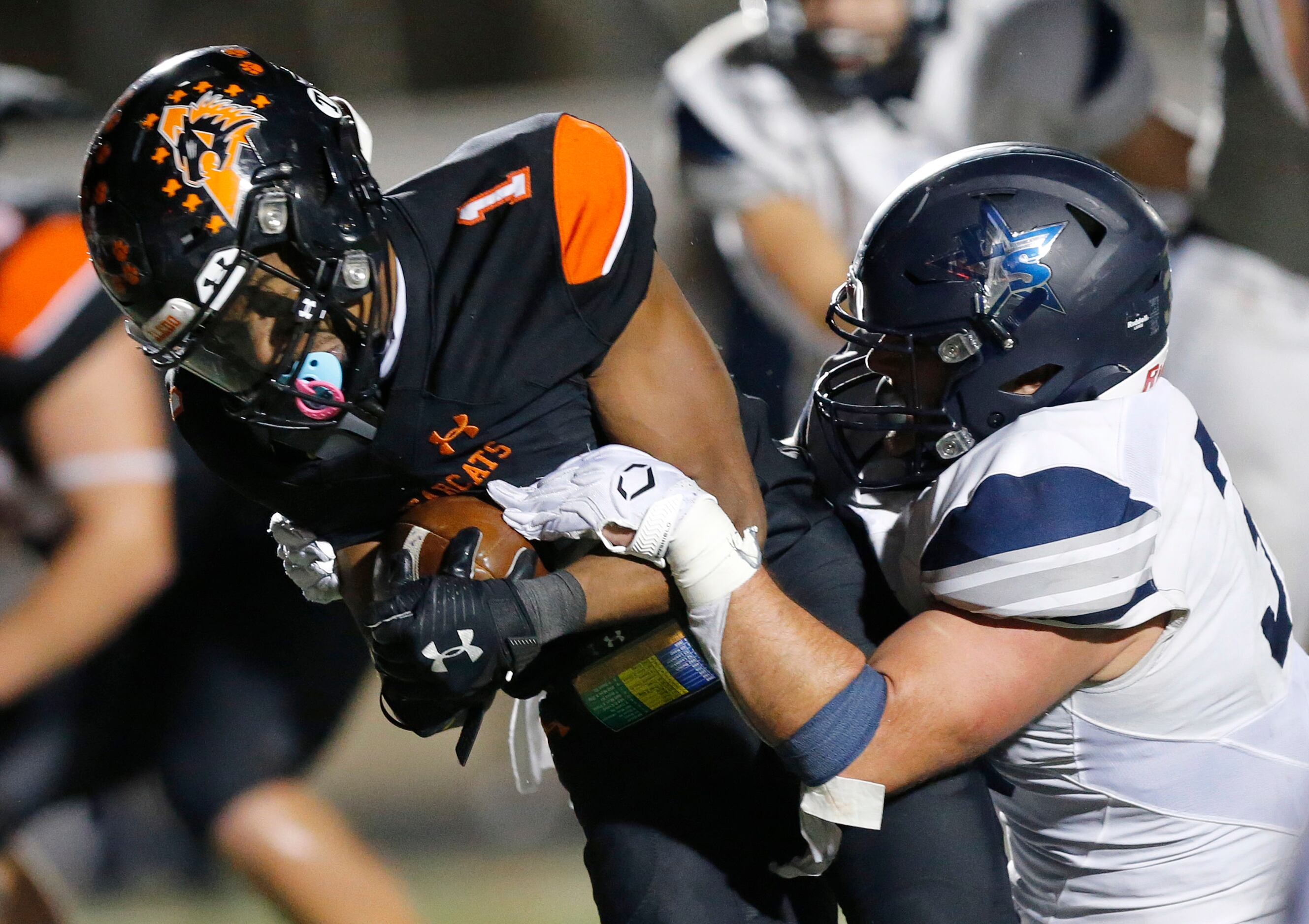 Frisco Lone Star linebacker Alessio Russolillo (33) tries to knock the ball out from Aledo...