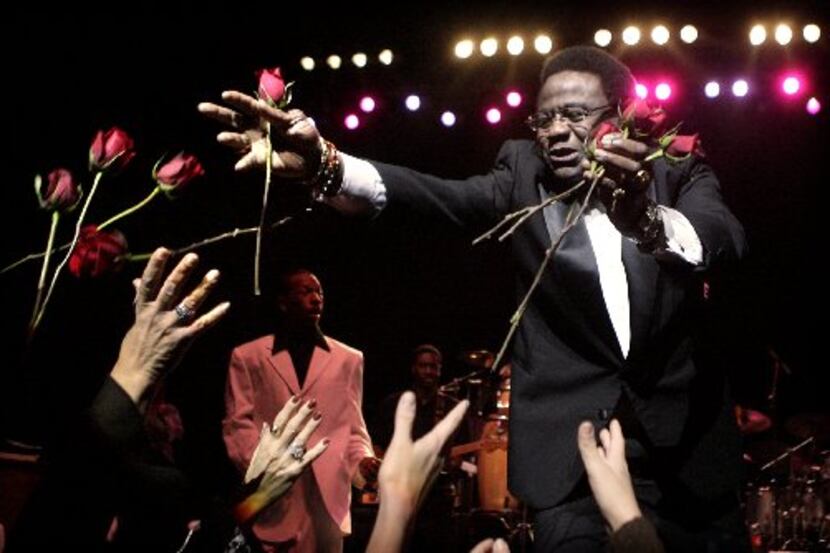 Singer Al Green tosses fresh-cut roses to ladies in the audience during the opening number...