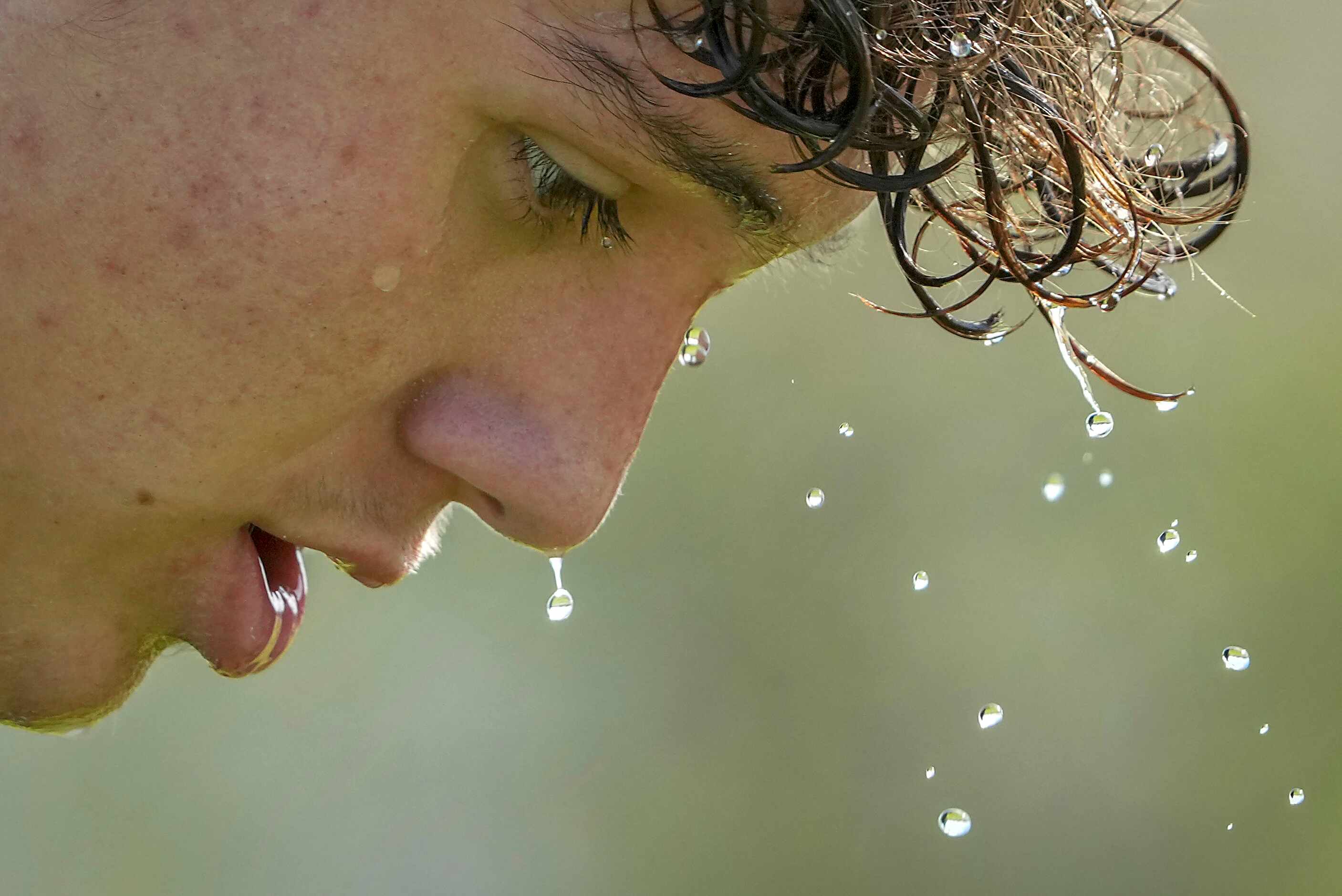 Water drips off of Seth Jackson as he cools off during a water break during the first day of...