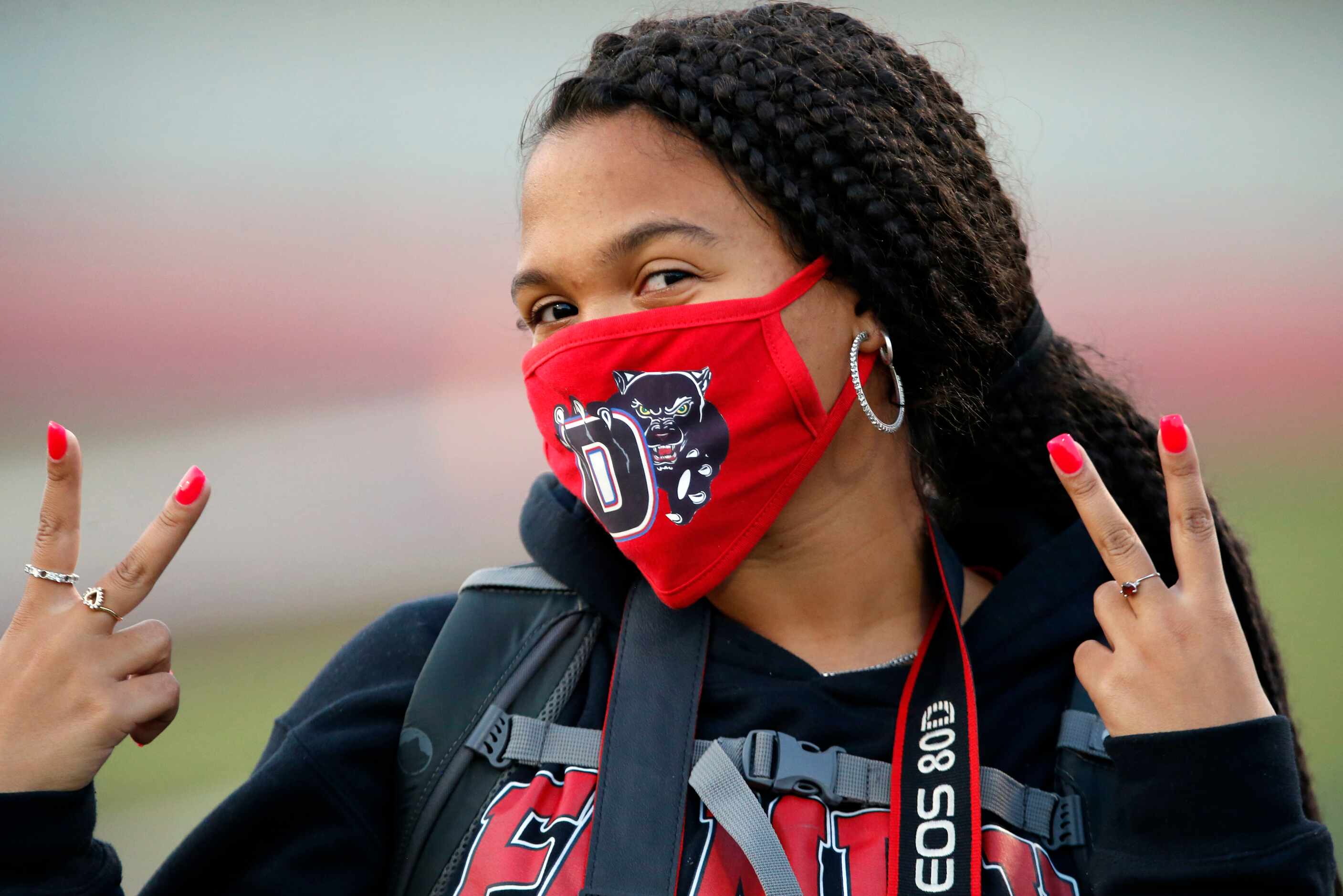 Duncanville student Megan Bryant sports a school logo facemark on the sideline before the...