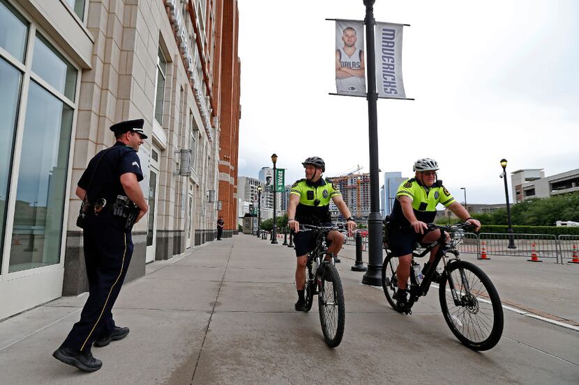 Sr. Cpl. Brett Rosen (left) talks with Dallas Police Bicycle Patrol officers at the entrance...