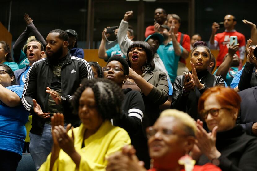 People celebrate after seeing the vote for earned paid sick time leave passed during a city...