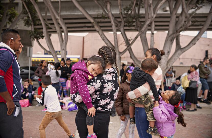 Undocumented migrants wait for asylum hearings outside the U.S. port of entry in Tijuana,...