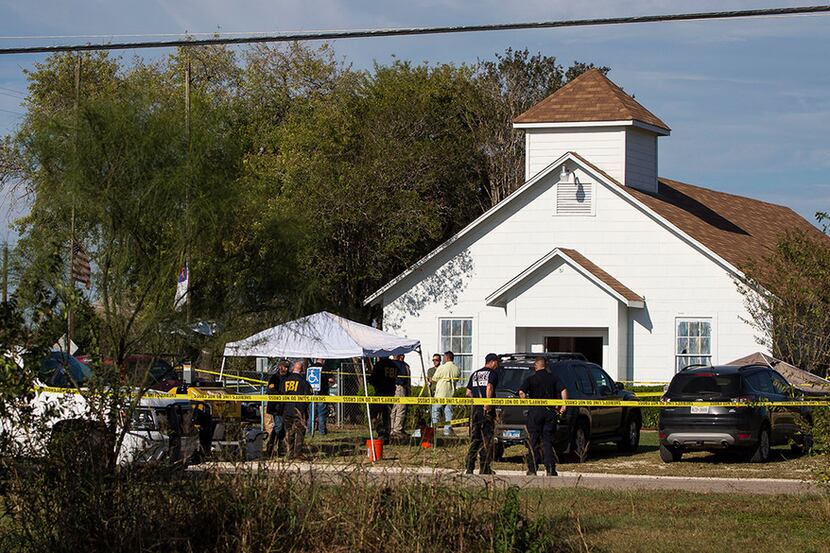 Law enforcement officials work at the scene of a fatal shooting at First Baptist Church in...