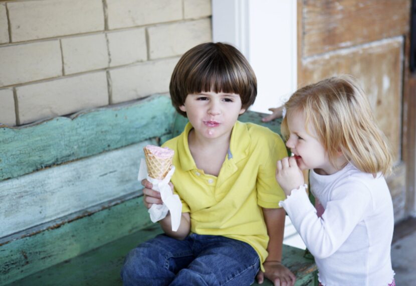 Brynn Hawkins, 3, tries to sample cotton candy ice cream from brother Braden Hawkins, 5,...