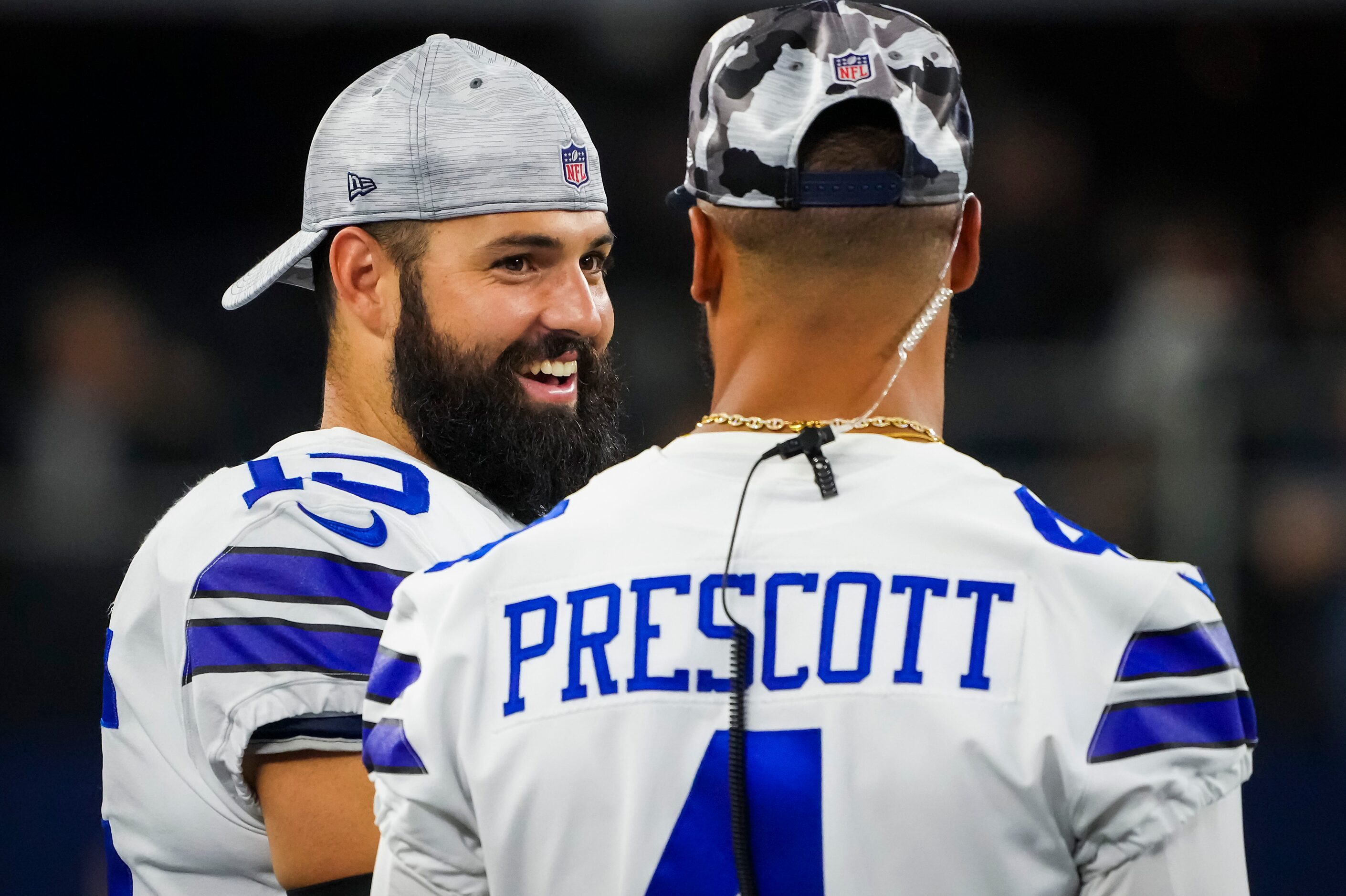 Dallas Cowboys quarterback Will Grier (15) talks with quarterback Dak Prescott (4) on the...