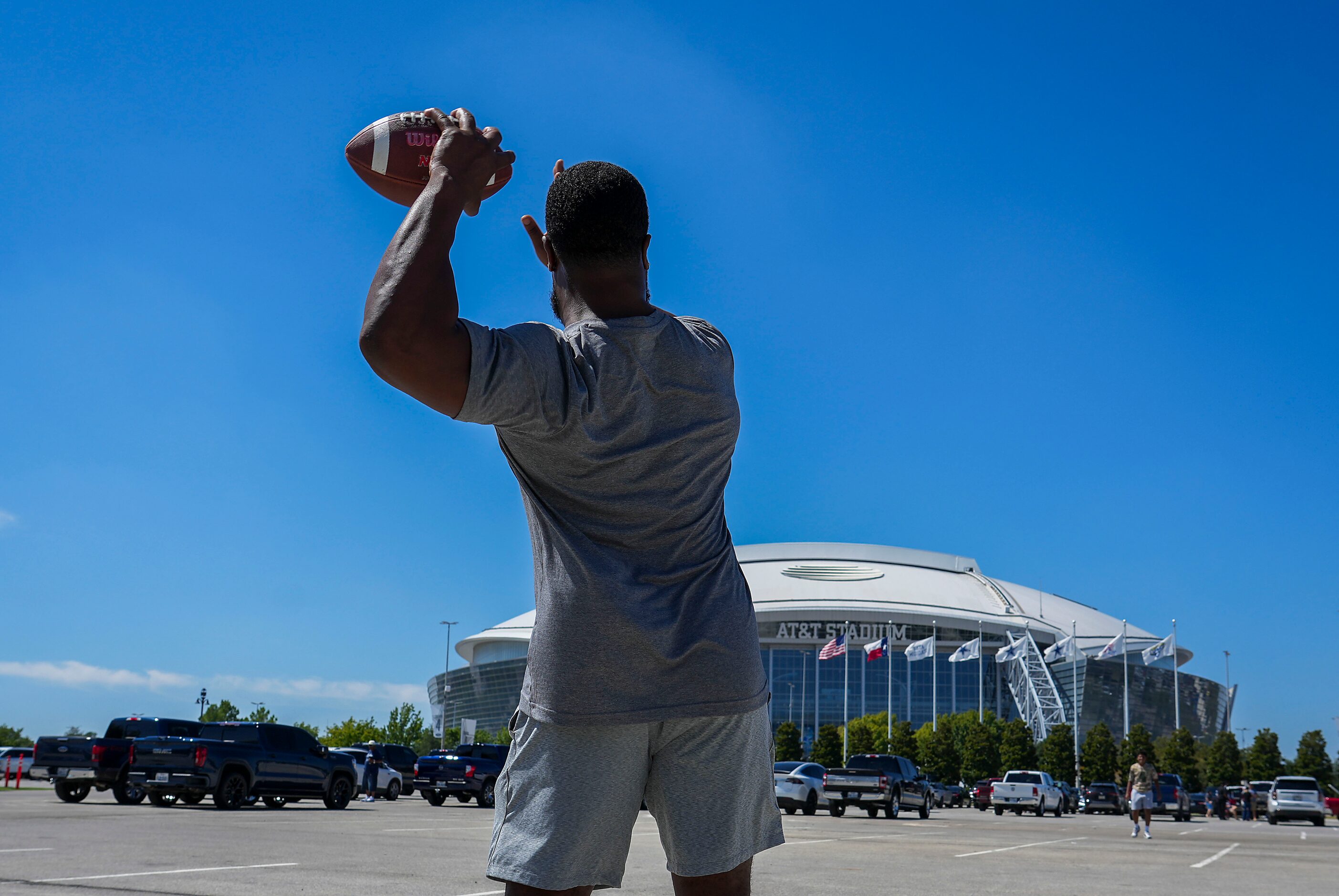 Jeremy Clayton tosses a football while tailgating before an NFL football game at AT&T...