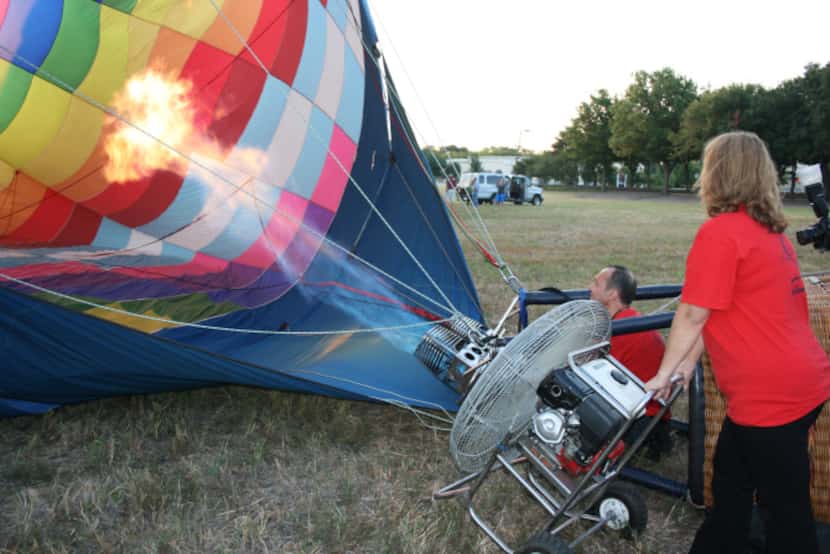 Luc Goethals shoots an open flame into his balloon, which is nicknamed "Zipper," while his...