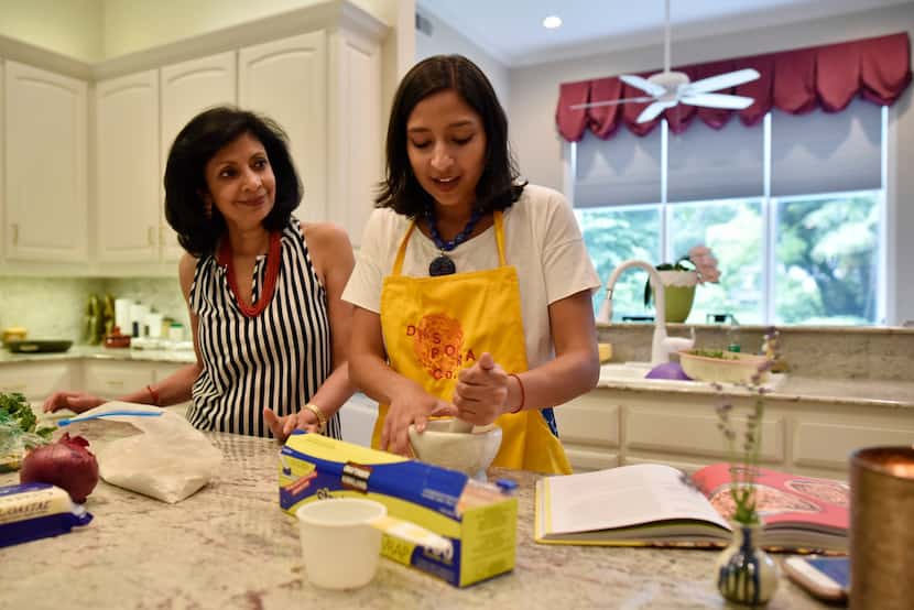 Priya Krishna, right, with her mother Ritu Krishna, work together to prepares dishes of roti...
