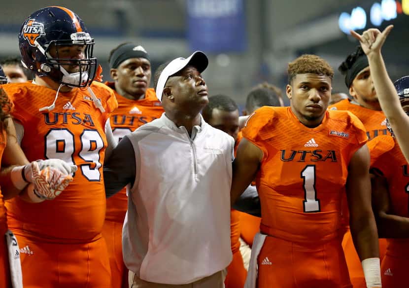 UTSA head coach Frank Wilson, center, stands with players including Baylen Baker (99), and...