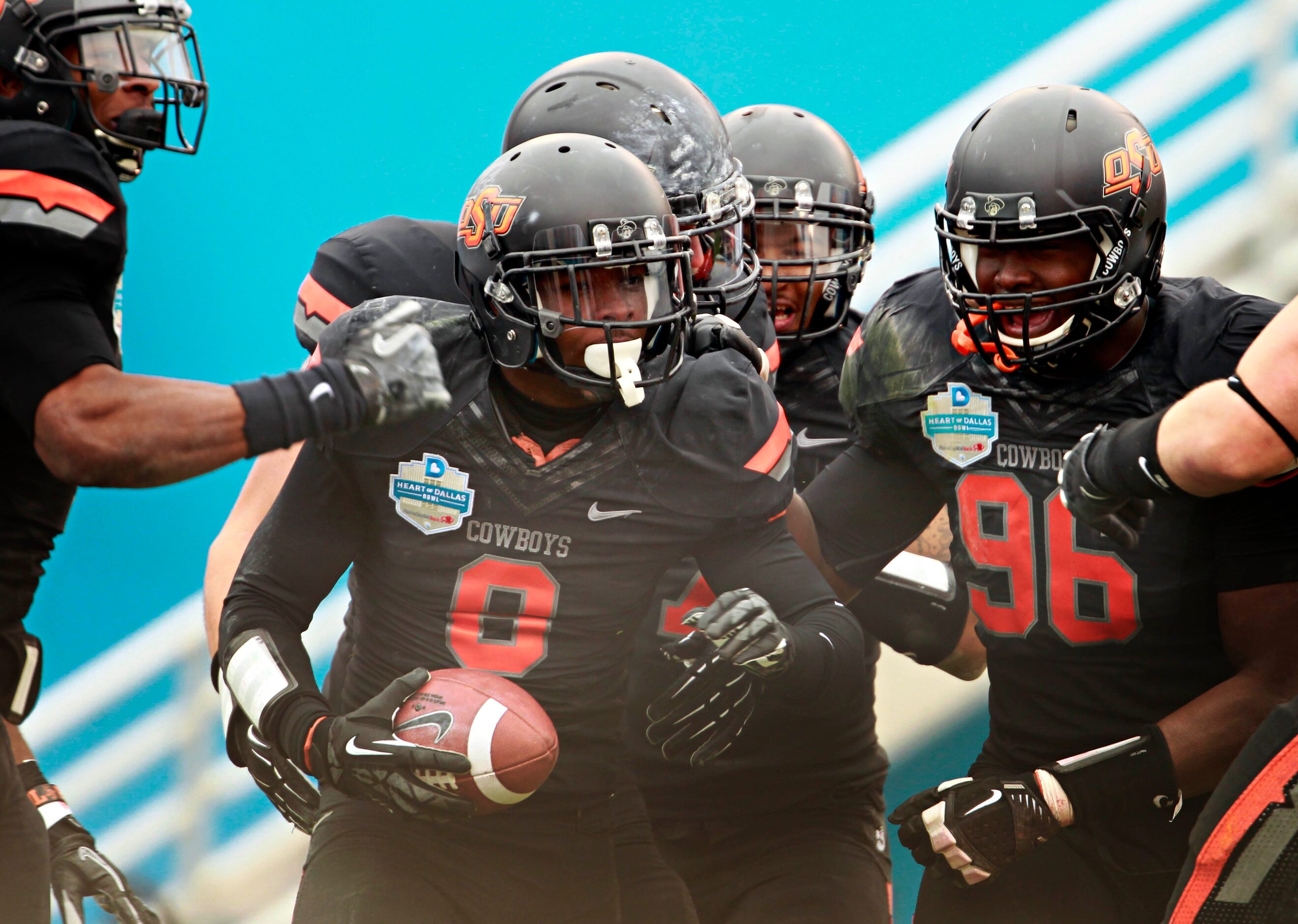 Oklahoma State Cowboys players celebrate with safety Daytawion Lowe (8) after he recovered a...