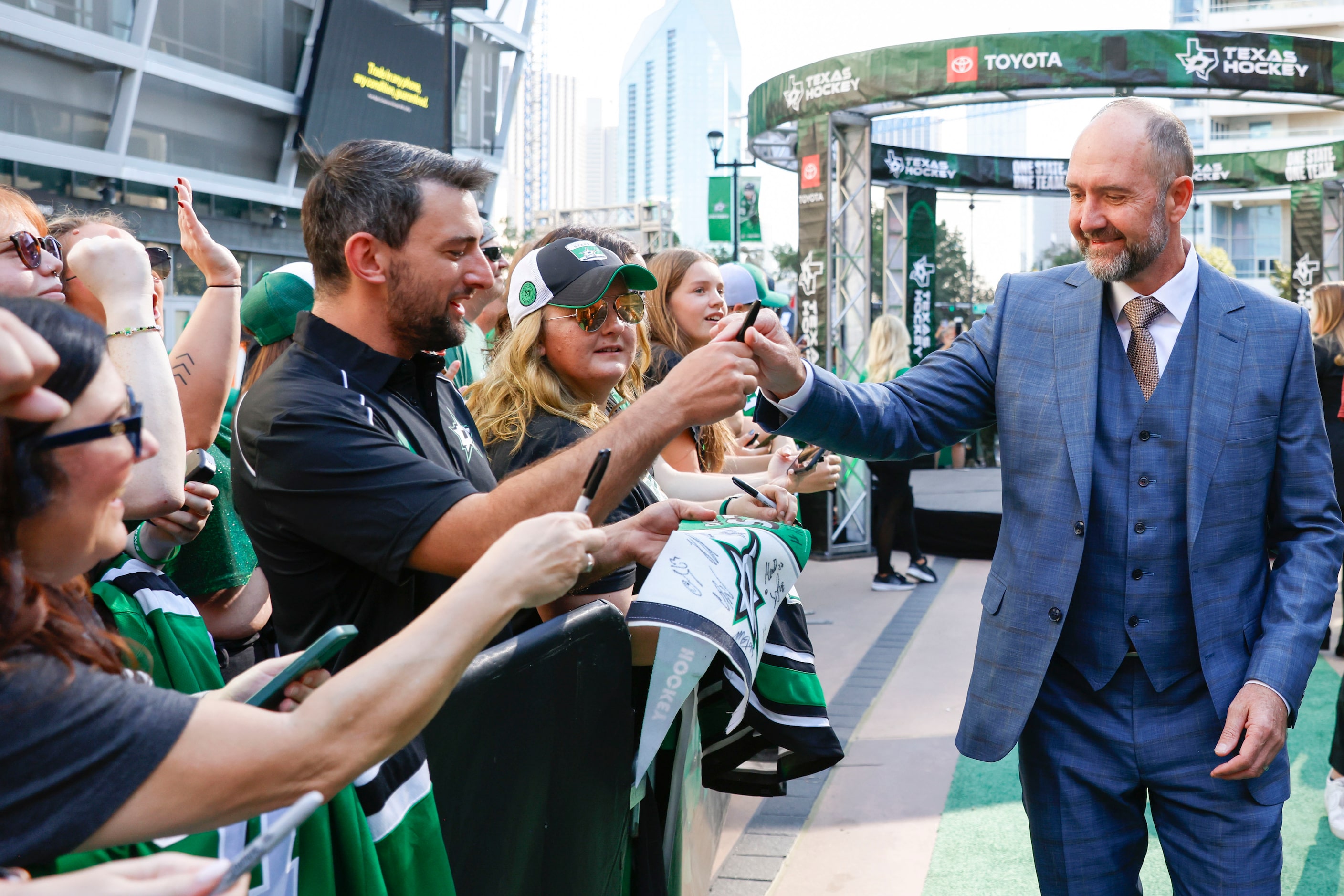 Dallas Stars head coach Peter DeBoer gives autographs to a fan during Dallas Stars' home...