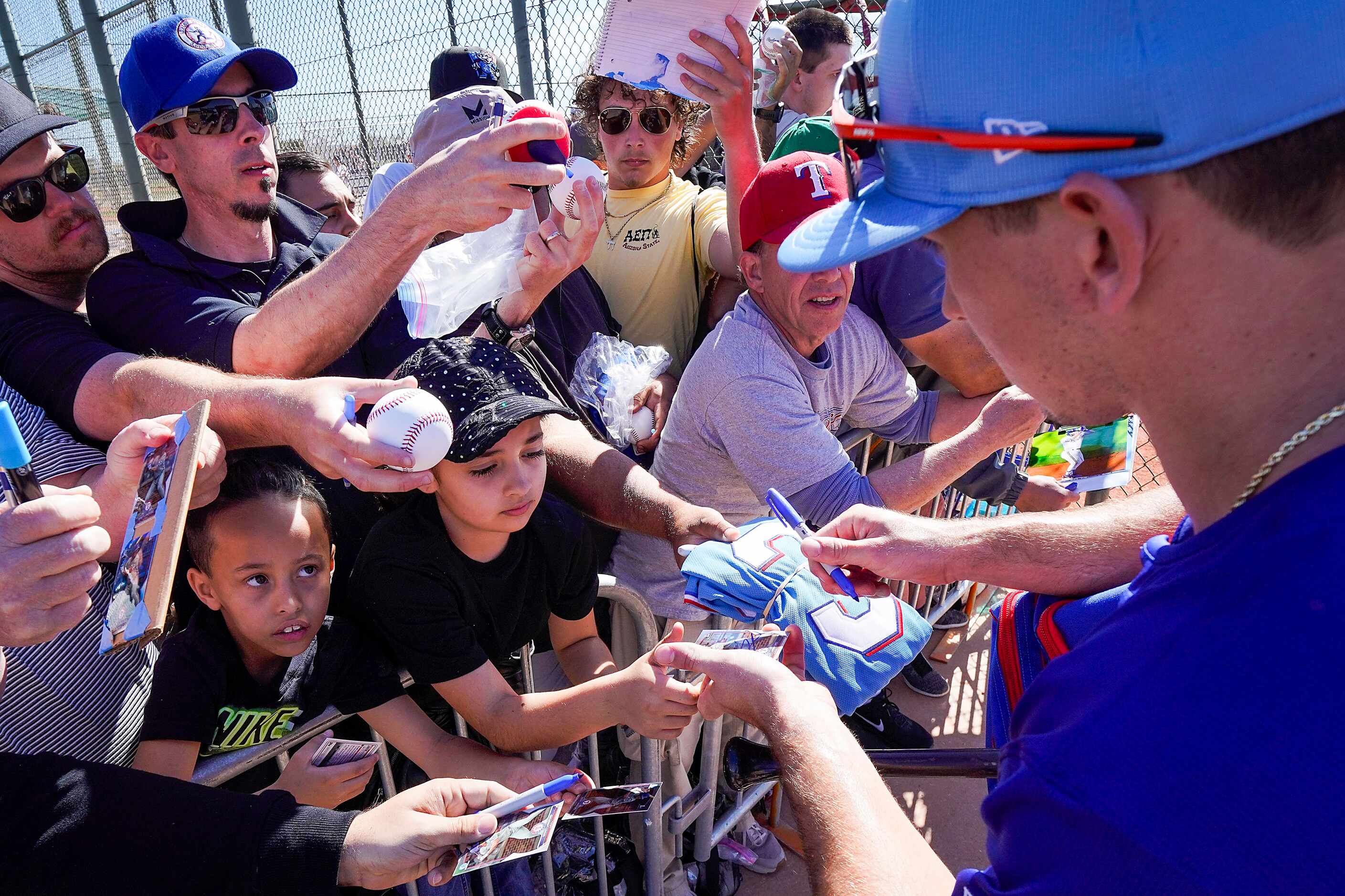 Texas Rangers outfielder Wyatt Langford signs autographs during the first full squad spring...
