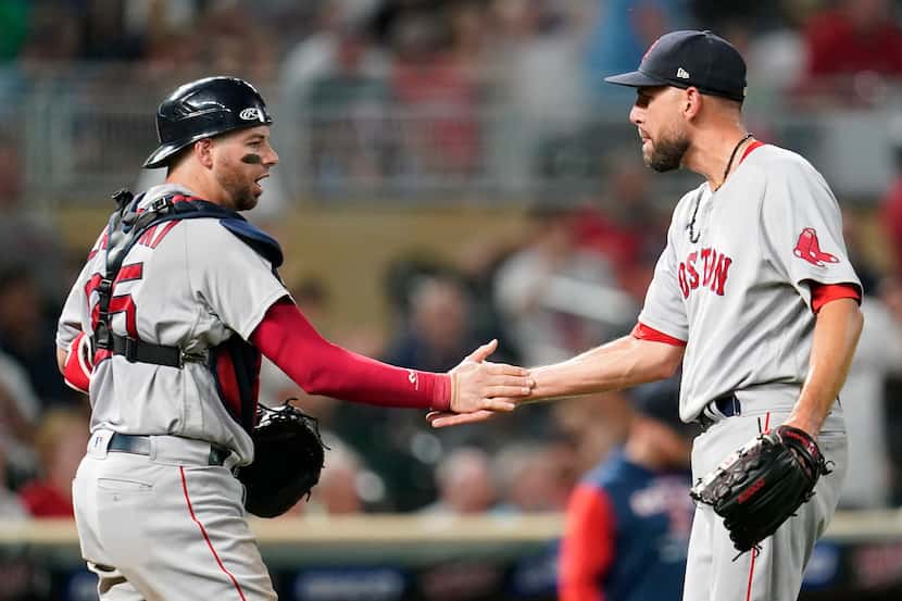 Boston Red Sox catcher Kevin Plawecki, left, and relief pitcher Matt Barnes shake hands...