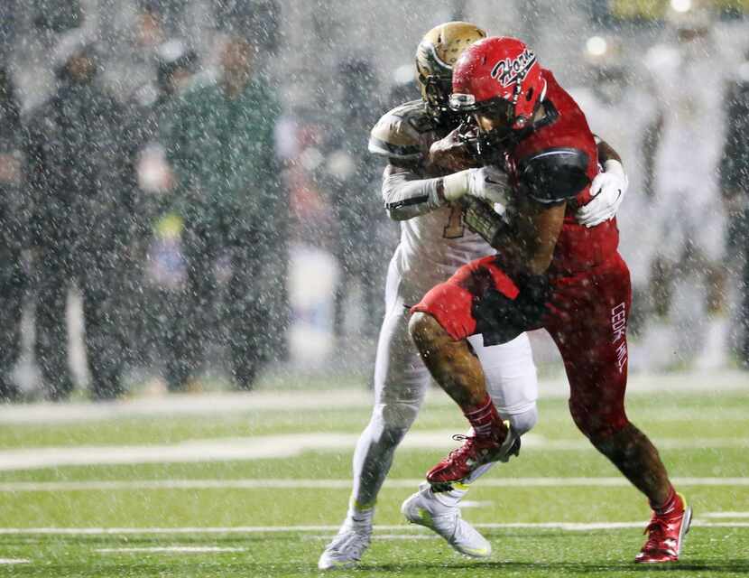 Cedar Hill's Aery Davis (12) is tackled by DeSoto'sIsaiah Stewart (13) during the first half...