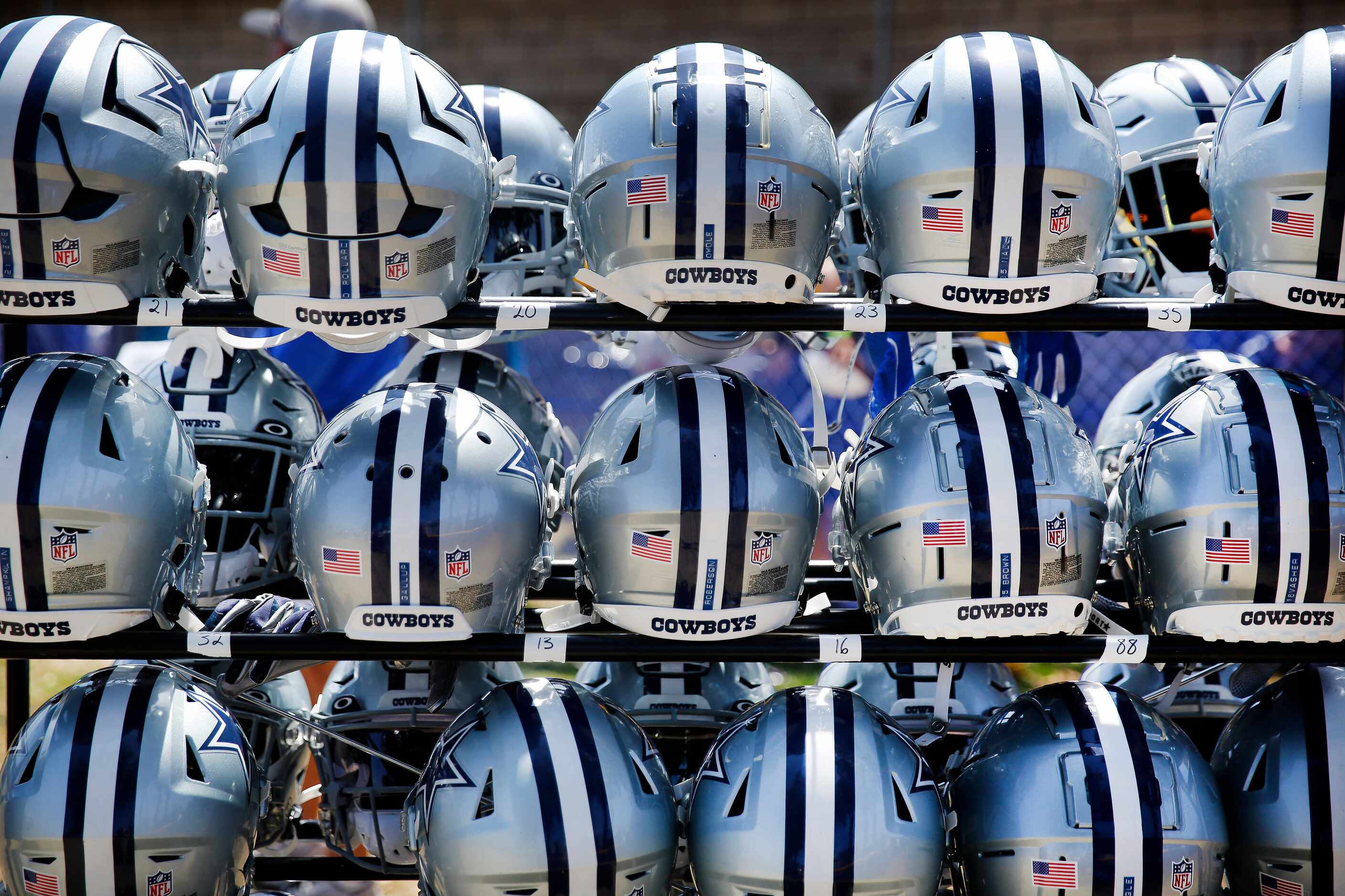 Dallas Cowboys players helmets are lined up on a rack as players had an option to wear them...