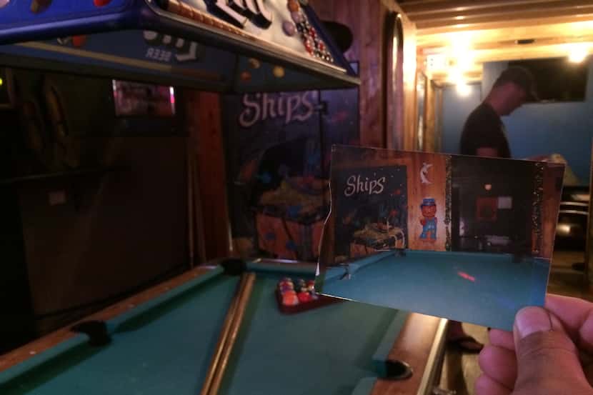 Co-owner Matt Pikar holds a photo of the old pool table which still resides in the main bar...