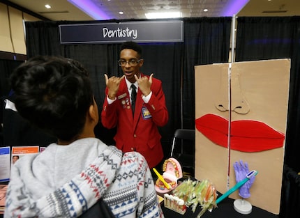 Austin Elliott (center) talks to Larry Hernandez about the Grand Prairie ISD dentistry...