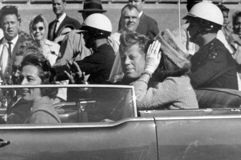 In this Nov. 22, 1963 photo, President John F. Kennedy waves from his car in a motorcade in...
