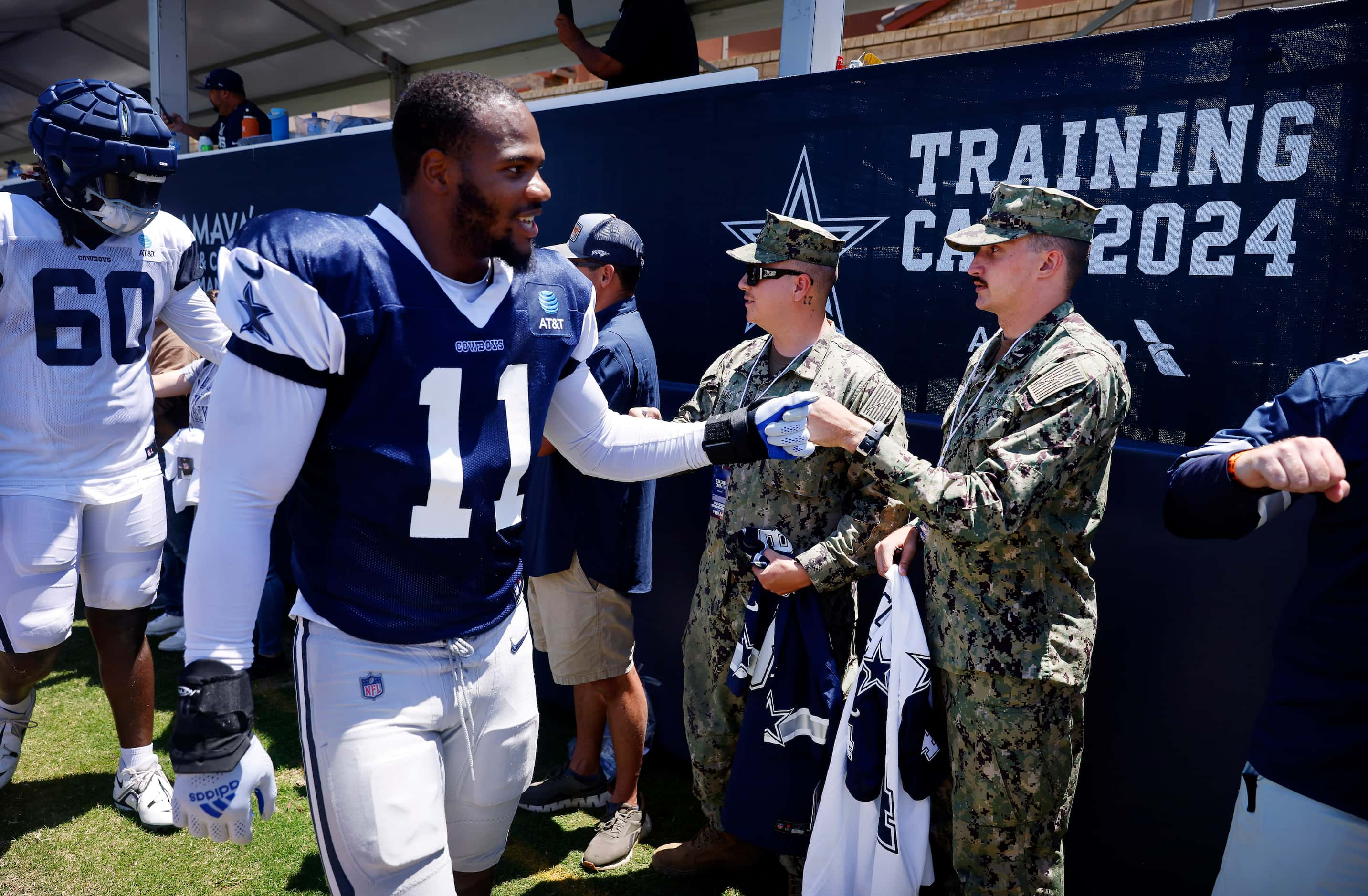 Dallas Cowboys linebacker Micah Parsons (11) fist bumps Naval Builder Third Classmen Caleb...