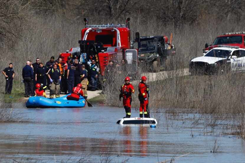 Dallas Fire-Rescue personnel and others work the scene where a truck was found submerged in...