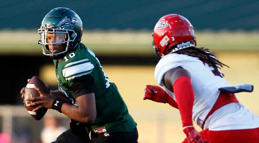 Waxahachie quarterback Roderick Hartsfield (10) looks for a receiver as he is pursued by...