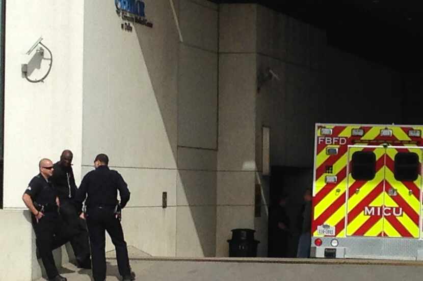 Dallas police officers wait outside Baylor University Medical Center in Dallas, as they...